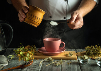 Hands skillfully add sugar to a steaming cup of herbal tea, surrounded by fresh herbs and kitchen...