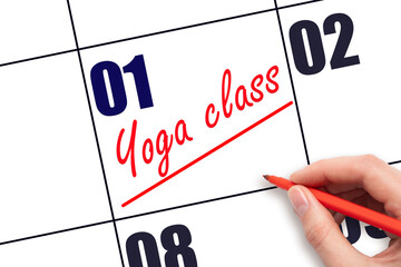 1st day of the month.  Hand writing Yoga class reminder and drawing a line on calendar with red pen...