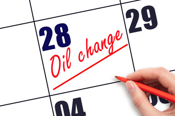 28th day of the month.  Hand writing Oil change reminder and drawing a line on calendar with red...