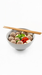 Minimalist modern presentation of bakso in a white ceramic bowl with chopsticks and sambal, isolated on a clean white background