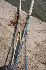Ropes are carefully tied to secure a boat at a river lake port. The docking process occurs under...