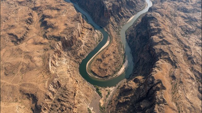 Aerial view of a meandering river in a desert canyon - Powered by Adobe