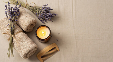 Relaxation essentials including towels, lavender, and candle for a calming spa experience, copy space on the right