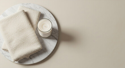 Relaxing spa setup with towels and candle on marble tray in tranquil setting, copy space on the right