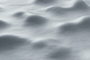 Close up abstract view of undulating snowdrifts with soft shadows and light