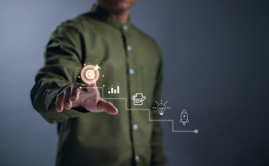 Goals and targets concept, businessman tapping virtual graphics dartboard and arrows to set business goal, startup, vision, business process planning for success