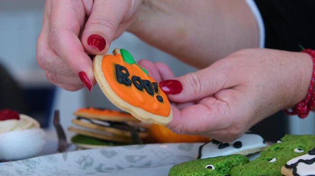Pumpkin Boo cookie ghost shaped Halloween cookie with Boo word stands by toadstools on fallen tree in dark autumn forest. Selective focus. Real time video. Holiday food theme.