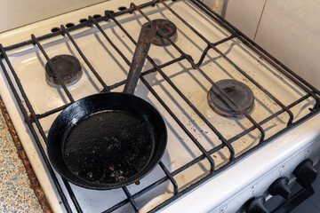 Dirty greasy frying pan on vintage gas stove