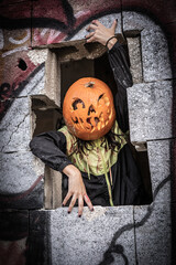 Halloween Pumpkin Head Girl in Urban Graffiti Scene with a red balloon.