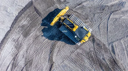 Fotobehang Vrachtwagen Aerial, overhead image of a bulldozer working on construction site. Smoothing gravel surface for new road. Earthmoving, excavations, digging on soils   © Thomas