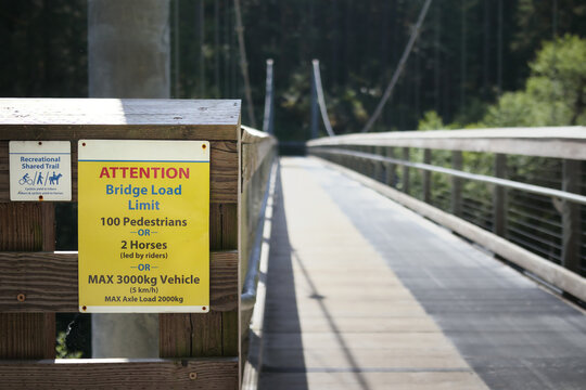 Bridge load limit sign for Suspension bridge. Safety sign. Shared hiking trail for hikers, mountain biking and horses. Seymore river suspension bridge, North Vancouver, BC, Canada. Selective focus.