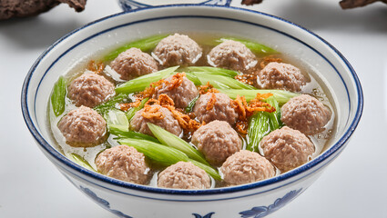 Bakso meatballs close-up in a rich broth with fresh green celery and fried shallots, high-resolution, appetizing and vibrant, food magazine style