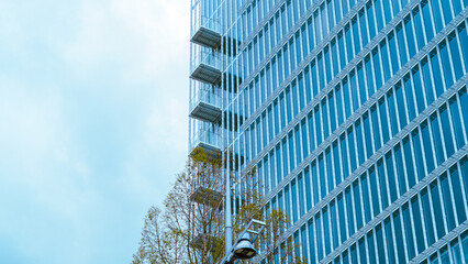 Glass buildings and geometric shapes in modern blue architecture background..