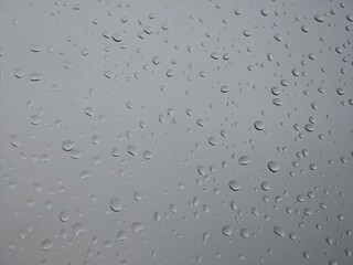 Raindrops clustering on a window during a cloudy day in the city