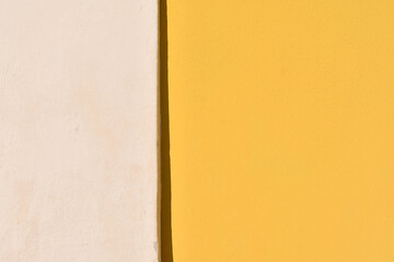 Close-up of a wall painted in light pink and bright yellow, suitable for copy space, textures, background...