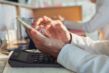 Close-up of hands using smartphone with digital banking icons overlay, calculator on desk,...