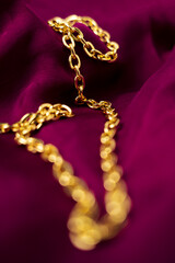 Luxury Gold Chain on Rich Burgundy Fabric: Elegant Jewelry Photography