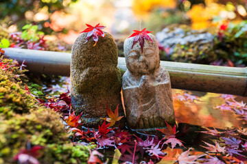 Jizu Buddha statue with red maple leaf on basin, Bishamondo, Kyoto