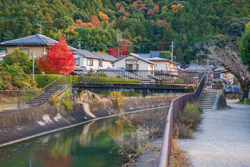 Japanese houses by lake Biwa canal with autumn colors, Kyoto