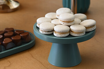 french macarons on a tray, elegant macarons dessert stand, white macarons with caramel filling, sweet party treat display