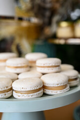 french macarons on a tray, elegant macarons dessert stand, white macarons with caramel filling, sweet party treat display