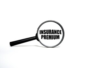 the word INSURANCE PREMIUM on the magnifying glass. magnifying glass concept on white background.