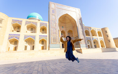 woman as a tourist have fun in front of Poi-Kalyan Kalyan mosque in bukhara Uzbekistan 