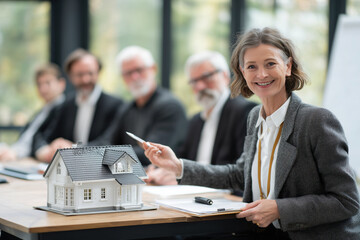 Presentation of construction project at meeting with female architect and model of country house on table