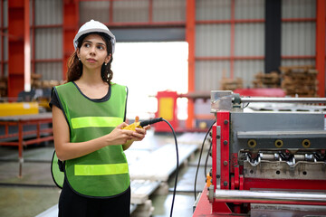 Engineer or worker operating remote switch to control machine in the factory
