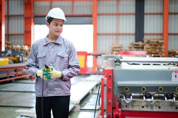 Engineer or worker operating remote switch to control machine in the factory