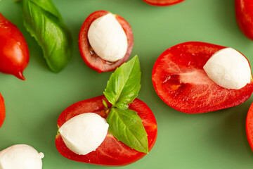 caprese ingredients on green background in studio