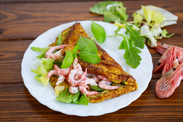 Homemade omelette with seafood on a dark wooden background