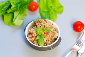 Buckwheat dinner with vegetables on a gray background