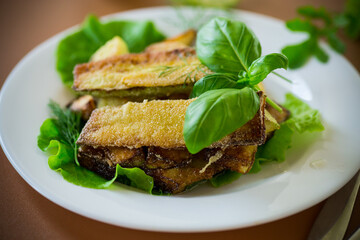 Vegetable appetizer of zucchini and dill on a brown background