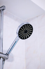 Modern chrome shower head with black surface and white nozzles