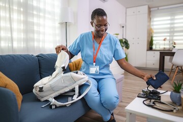Smiling nurse preparing medical bag for home visit