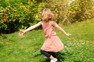 girl spinning in the garden in summer. sunny photo
