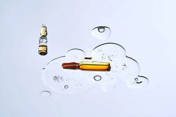 Ampoule in a drop of cosmetic preparation. View from below.