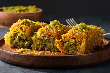 Delicious Turkish dessert pistachio kadayif. Burma kadayif on black background