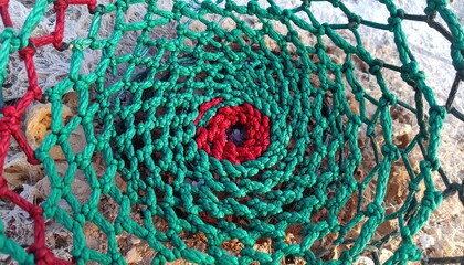Colorful Knitted Spiral Pattern of Twisted Fibers in Shades of Red, Green, and Black against Natural Background