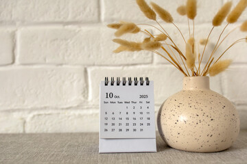 A calendar for October 2025 and a bouquet of dried flowers on the table. Hello, autumn.