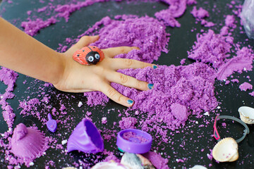 kinetic sand for kids on table. child playing