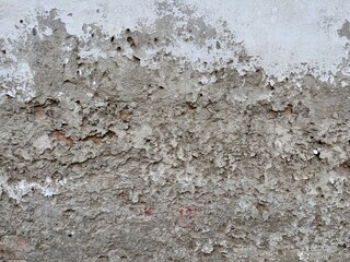 Close-up of a deteriorating wall showing raw cement and old white plaster, suitable for use in texture maps or distressed visual effects.