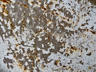 Texture of weathered metal showing peeling white paint and rust stains. Ideal for use in design,...
