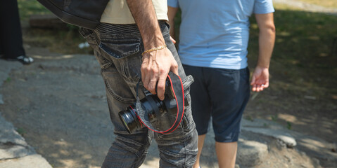 Photographer holding a digital camera taking pictures in nature.