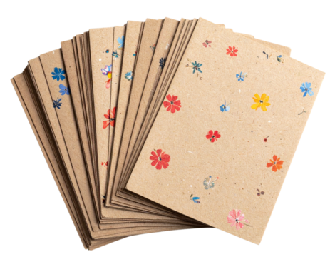 Stack of natural biodegradable seed paper cards with floral design, isolated on a transparent background