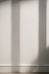 White wall with vertical shadow bands and subtle textured surface in soft natural light

