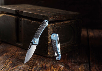 Luxury automatic knife in open and closed position on vintage box background.