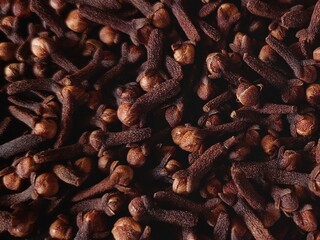 A pile of freshly dried clove spices. Cloves spice close up view. Cloves are aromatic dried flower buds. Cengkeh berasal dari Indonesia. Flat lay or top view.