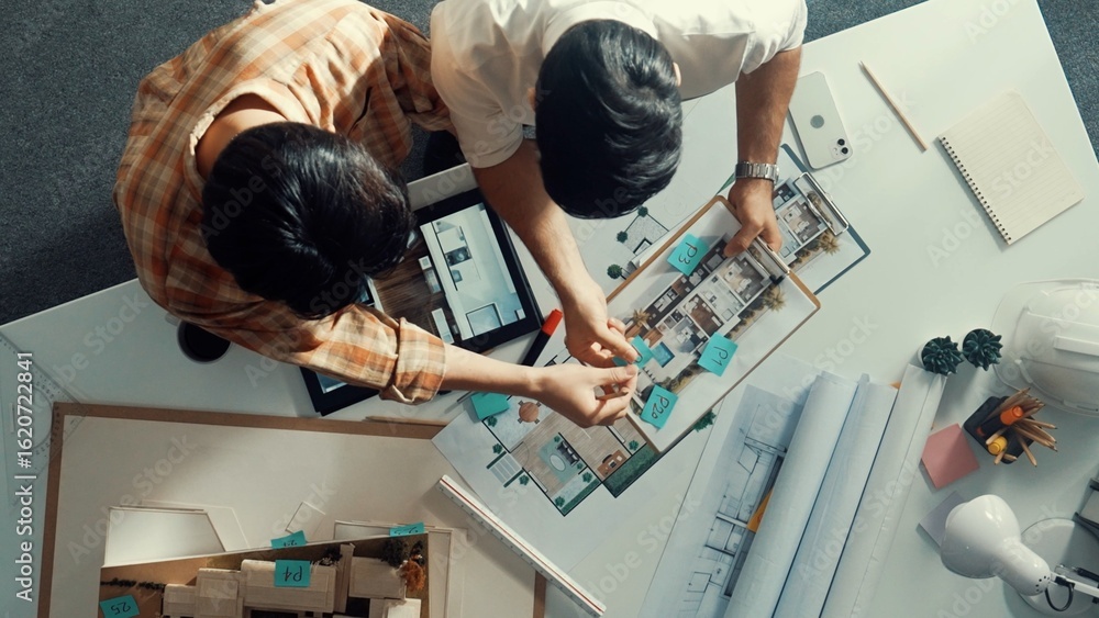 Poster top down view of skilled business man and colleague design house together. aerial view of architect 